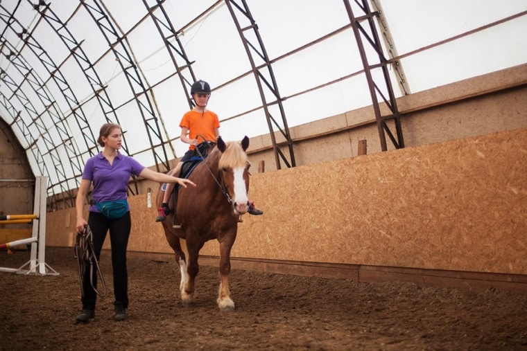 riding instructor and boy riding a horse