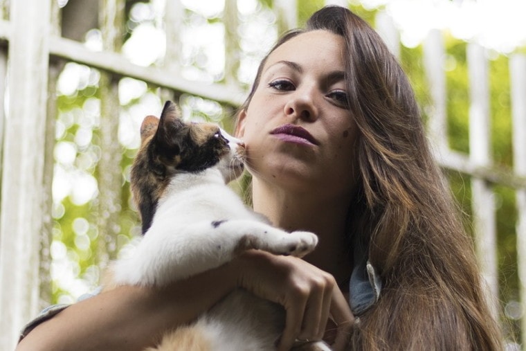 Cat kissing a woman on the cheek