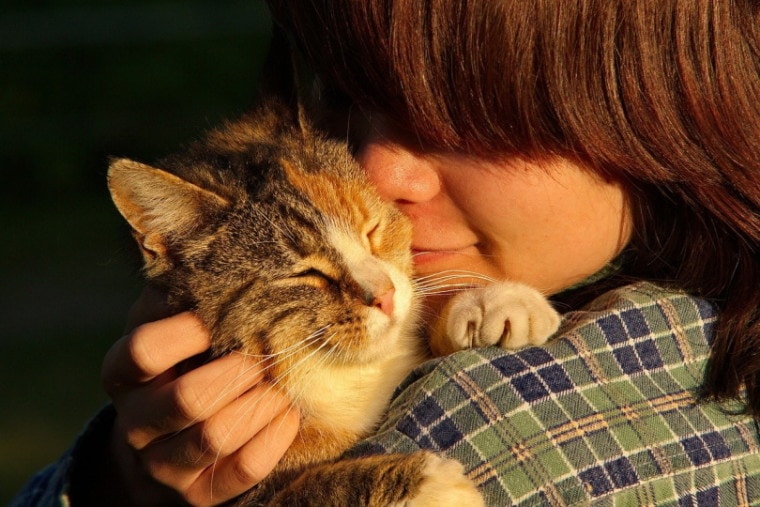 Woman carrying a cat close to her face