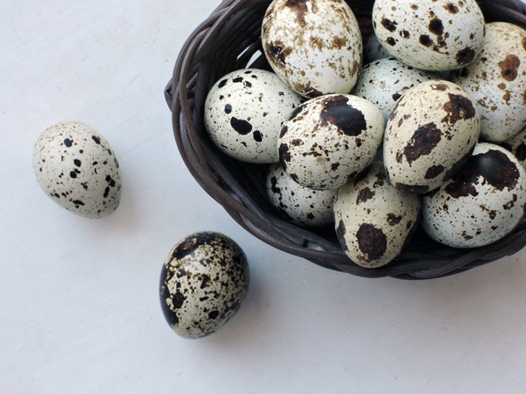 quail eggs in a basket and on a table
