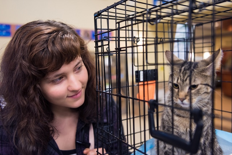 woman smiling by cage adoption
