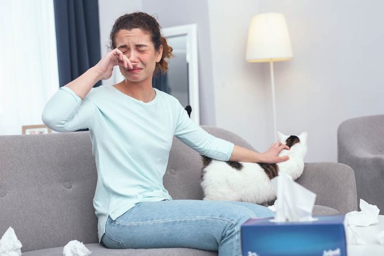 woman teary eyed due to cat allergy