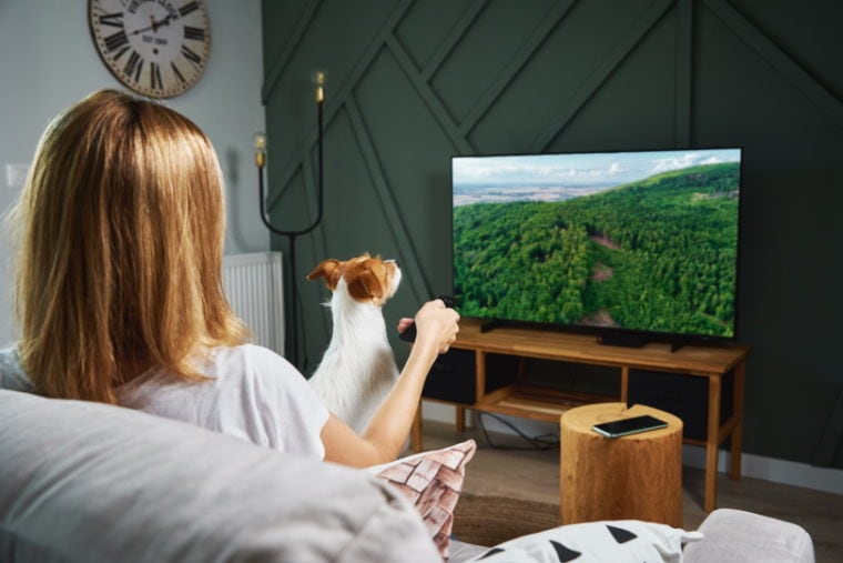 woman watching tv with her do