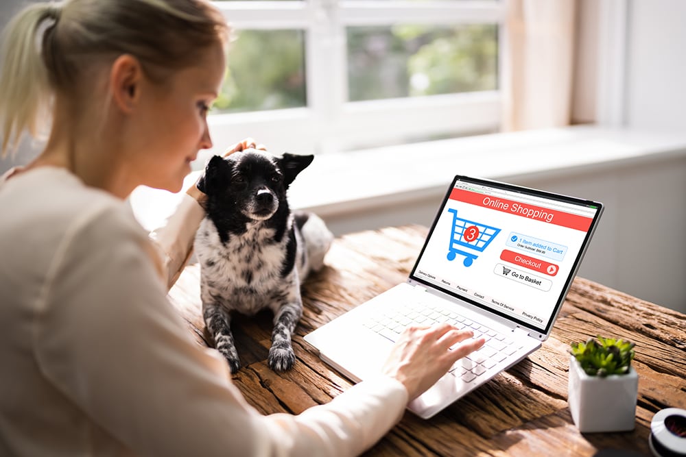 Mujer comprando productos en línea con un perro_Andrey Popov_Shutterstock