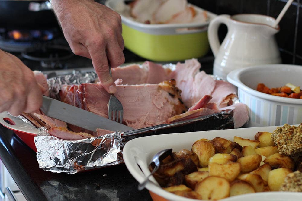 Man slicing a ham for christmas