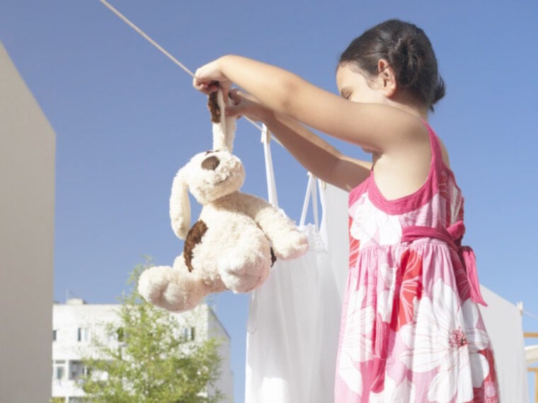 Young girl hanging washed cat toy
