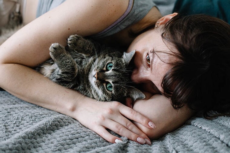 close up woman hugging a cat