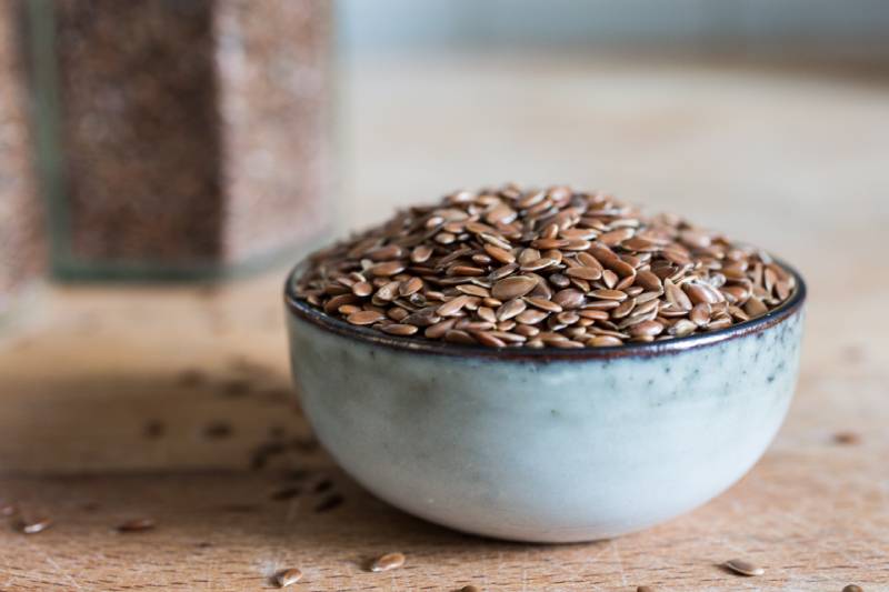 bowl on wooden table with healthy flaxseed grain cereal