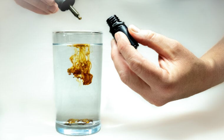 concentrated liquid colloidal silver being diluted in glass of water