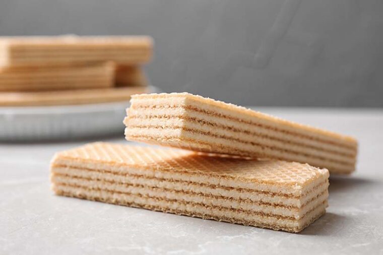 Delicious cream wafers on light grey marble table