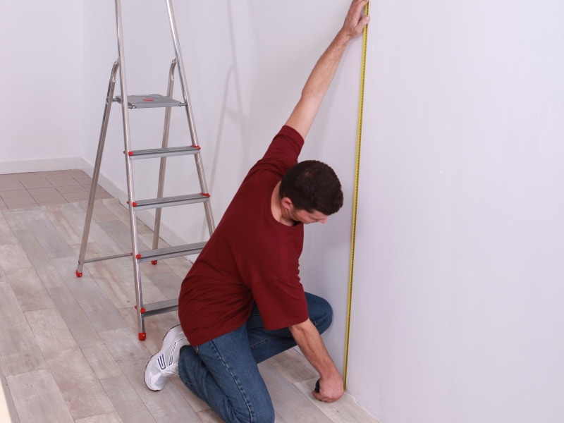 Man taking floor-to-ceiling measurement