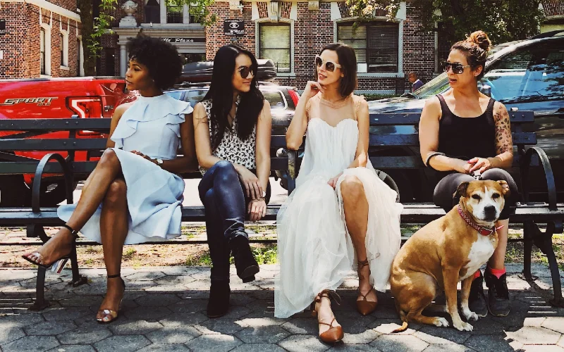 group of women sitting on benches outdoors with a dog
