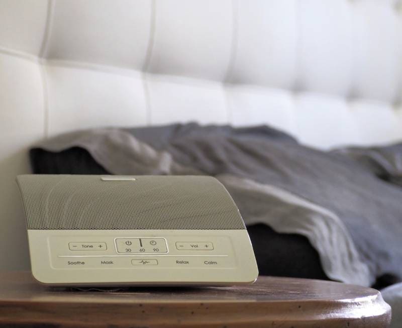 white noise machine at the bedside table
