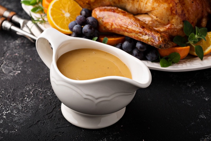 Homemade gravy in a sauce dish with turkey for