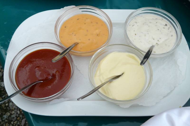 ketchup, mustard, ranch and mayonnaise in glass bowls