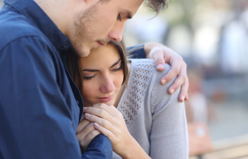 man comforting sad grieving woman