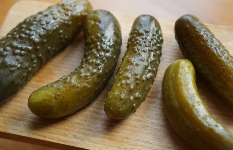 pickled cucumbers on a wooden surface