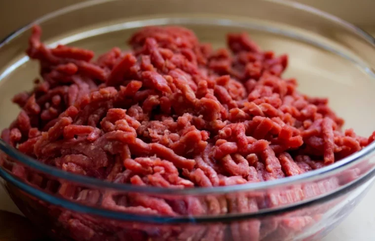 uncooked ground beef in glass bowl