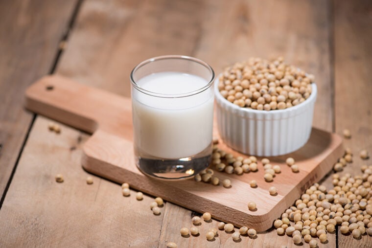 a glass of soymilk and bowl of soybeans