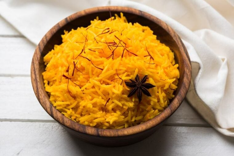 Saffron rice or Kesar chawal in a woowden bowl