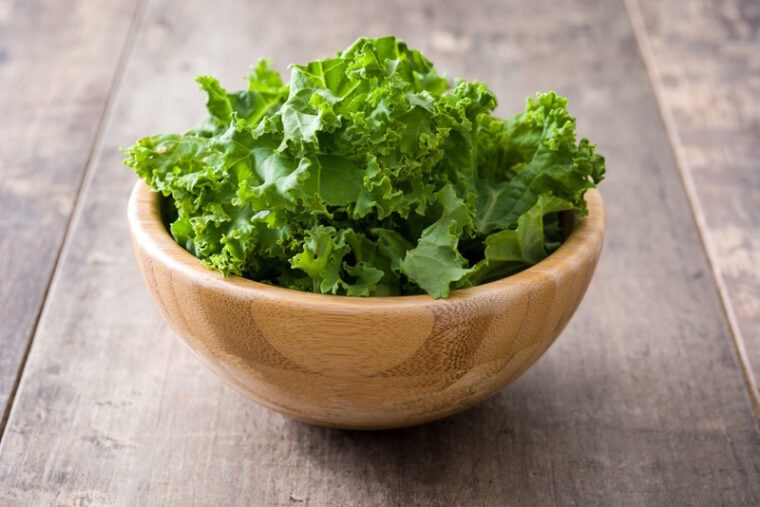 fresh kale in wooden bowl