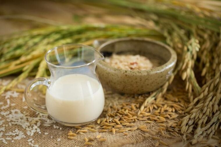 Rice milk and rice seeds on wooden table background
