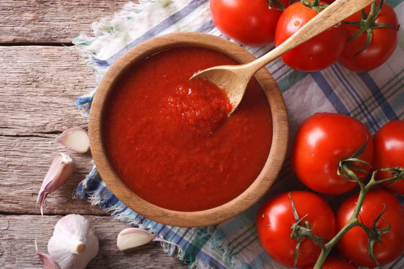 tomato sauce with garlic and basil in a wooden bowl