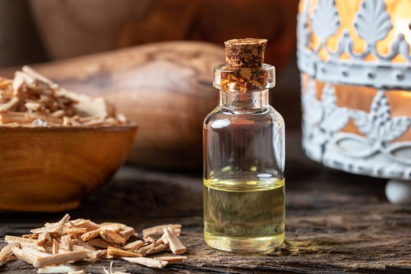 bottle of essential oil with cedar wood chips